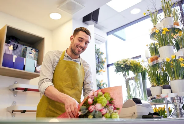 Florist inslagning blommor i papper på blomsteraffär — Stockfoto