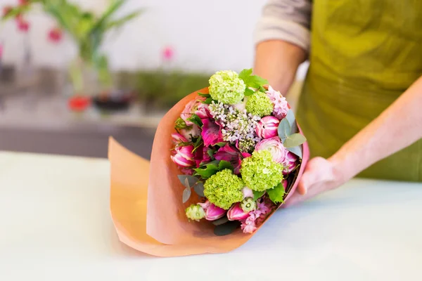 Florist inslagning blommor i papper på blomsteraffär — Stockfoto