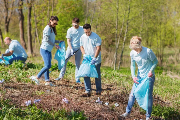 Volunteers with garbage bags cleaning park area — Stock Photo, Image