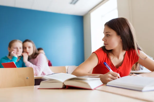 Estudantes fofocando atrás colega de volta na escola — Fotografia de Stock