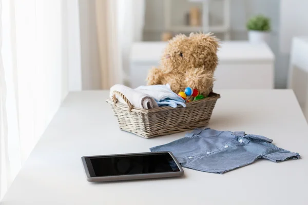 Close up van babykleding, speelgoed en tablet pc — Stockfoto