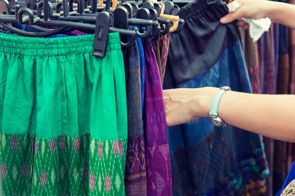 Hände in Nahaufnahme bei der Auswahl von Röcken auf dem Wochenmarkt — Stockfoto