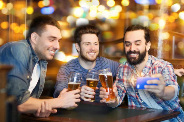 Vrienden nemen selfie en drinken bier bij bar — Stockfoto