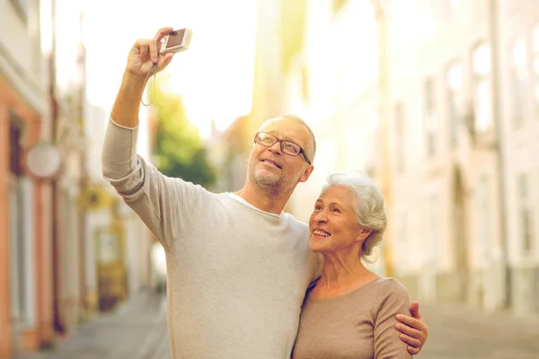 Senior couple photographing on city street — Stock Photo, Image
