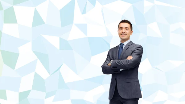 Uomo d'affari sorridente su blu bassa consistenza poli — Foto Stock