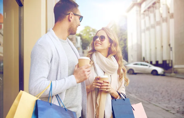 Casal feliz com sacos de compras e café na cidade — Fotografia de Stock