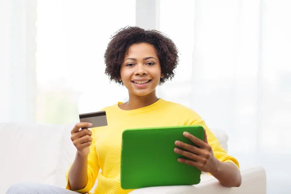 Glückliche Afrikanerin mit Tablet-PC und Kreditkarte — Stockfoto