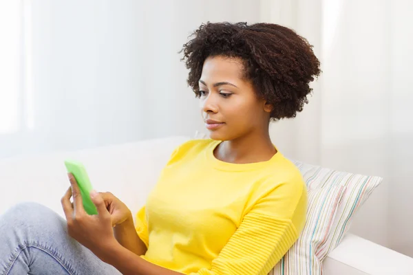 Happy african woman with smartphone at home — Stock Photo, Image
