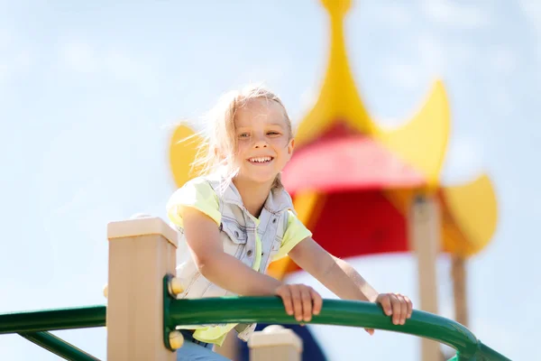 Fröhliches kleines Mädchen klettert auf Kinderspielplatz — Stockfoto