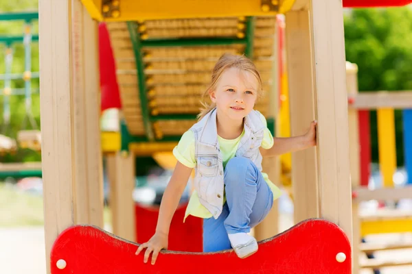 Fröhliches kleines Mädchen klettert auf Kinderspielplatz — Stockfoto