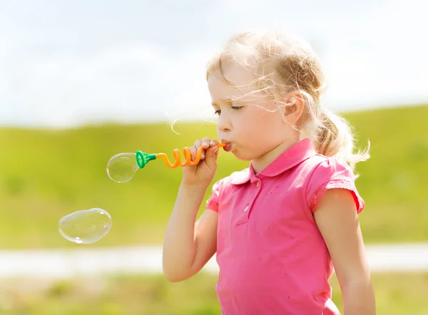 Menina soprando bolhas de sabão ao ar livre — Fotografia de Stock