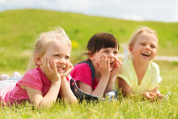 Group of kids lying on blanket or cover outdoors — Stock Photo, Image