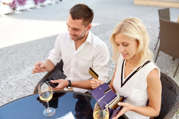 Feliz pareja con billetera pagando la factura en el restaurante —  Fotos de Stock