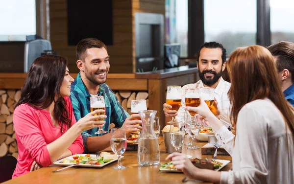 Přátelé stolování a pití piva v restauraci — Stock fotografie