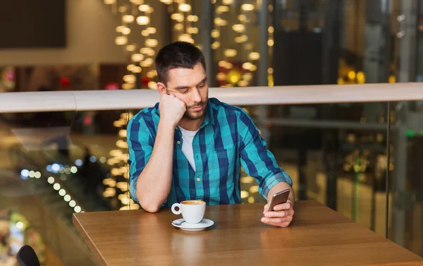 Hombre con teléfono inteligente y café en el restaurante —  Fotos de Stock