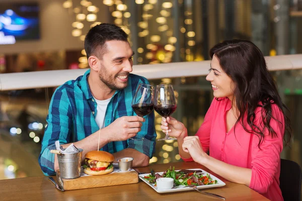 Pareja feliz cenar y beber vino en el restaurante —  Fotos de Stock