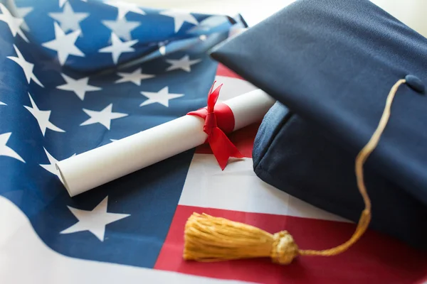 Chapéu de solteiro e diploma na bandeira americana — Fotografia de Stock