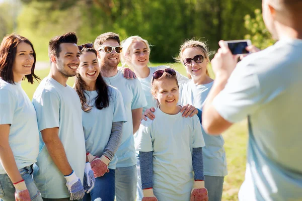 Grupo de voluntarios tomando fotos por teléfono inteligente — Foto de Stock