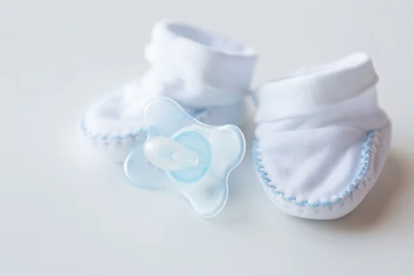 Close-up de botas de bebê e chupeta para recém-nascido — Fotografia de Stock