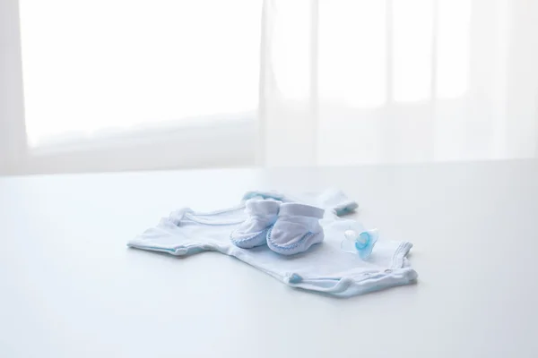 Close up van de kleren van de jongens van de baby voor pasgeboren op tafel — Stockfoto