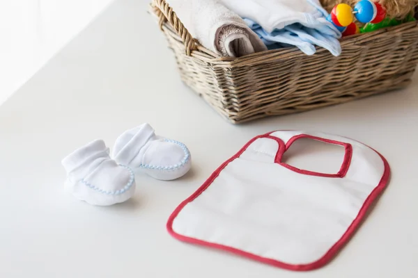 Close up van baby bootees, slabbetje en pasgeboren spul — Stockfoto