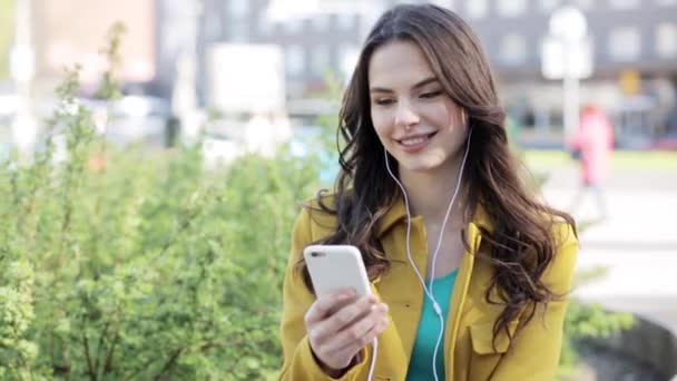 Ευτυχισμένος νεαρή γυναίκα με το smartphone και ακουστικά — Αρχείο Βίντεο