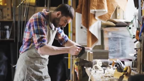 Carpintero trabajando con sierra y madera en taller — Vídeo de stock