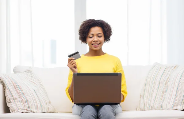 Lykkelig afrikansk kvinde med laptop og kreditkort - Stock-foto