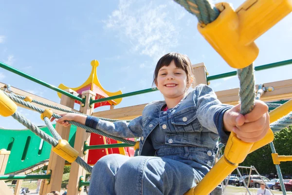 Felice bambina arrampicata sul parco giochi per bambini — Foto Stock