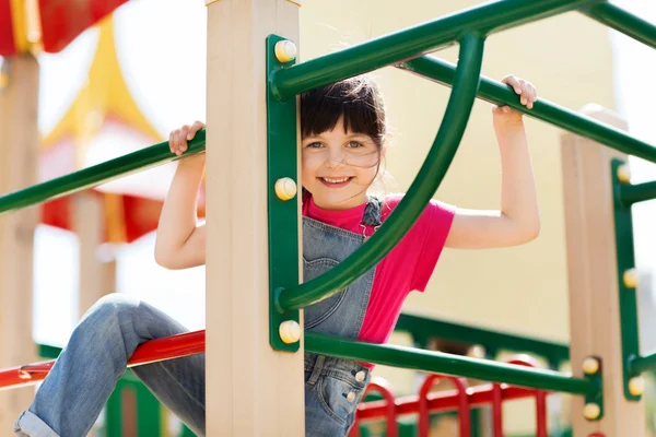 Fröhliches kleines Mädchen klettert auf Kinderspielplatz — Stockfoto