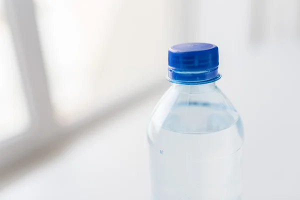 Primo piano della bottiglia con acqua potabile sul tavolo — Foto Stock