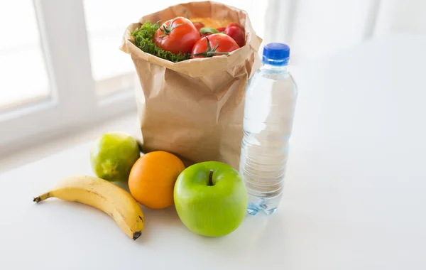 Cesta de comida vegetal e água na cozinha — Fotografia de Stock