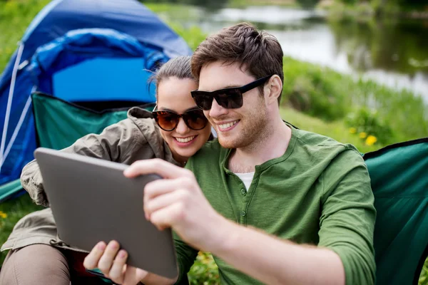 Feliz pareja con la tableta PC en la tienda de campaña —  Fotos de Stock