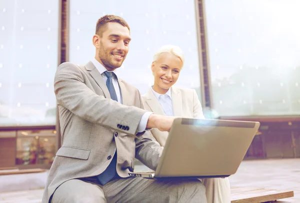 Empresários sorridentes com laptop ao ar livre — Fotografia de Stock