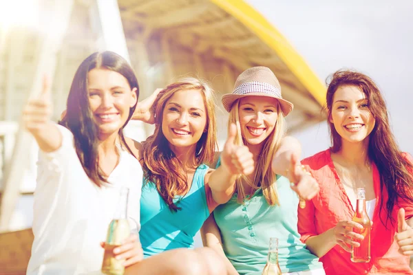 Girls with drinks on beach — Stock Photo, Image