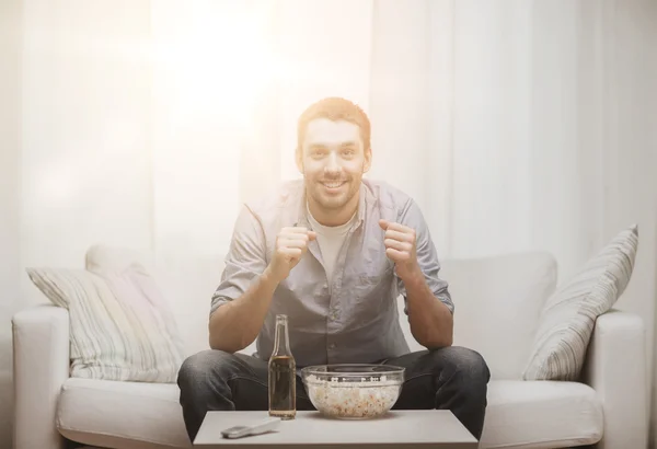 Glimlachende man kijken naar sport thuis — Stockfoto