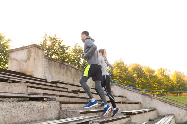 Couple running upstairs on stadium — Stock Photo, Image