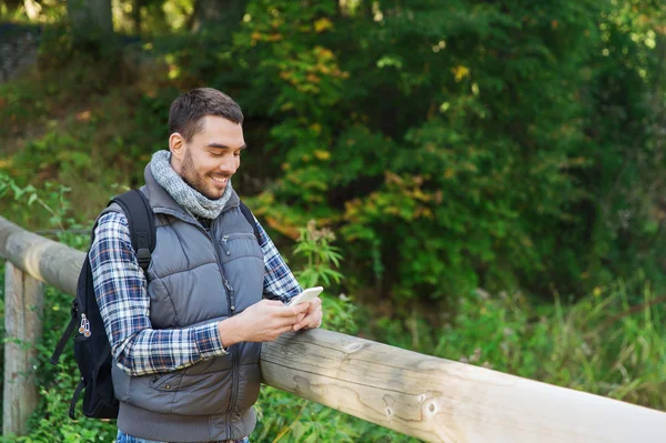 Homme heureux avec sac à dos et smartphone à l'extérieur — Photo