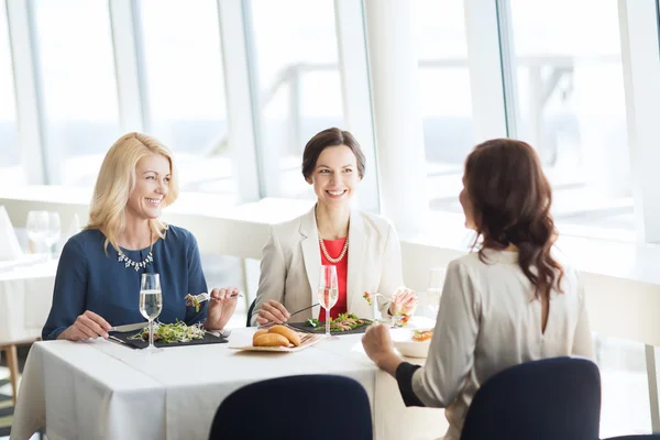 Mujeres felices comiendo y hablando en el restaurante —  Fotos de Stock