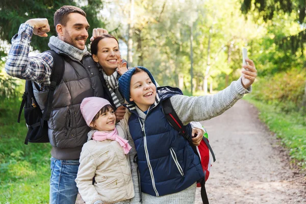 Family with backpacks taking selfie by smartphone — Stock Photo, Image