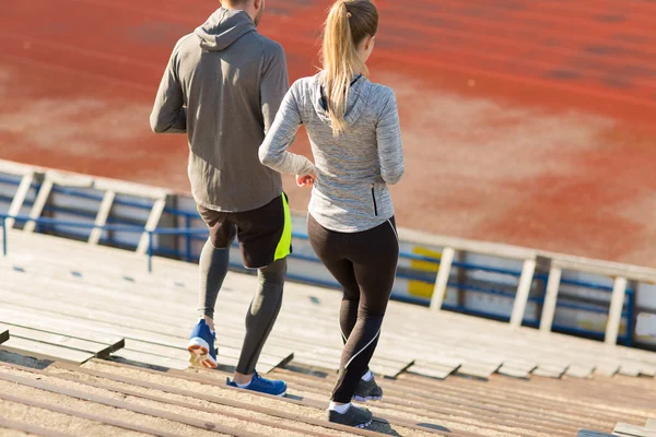 Paar läuft im Stadion die Treppe hinunter — Stockfoto