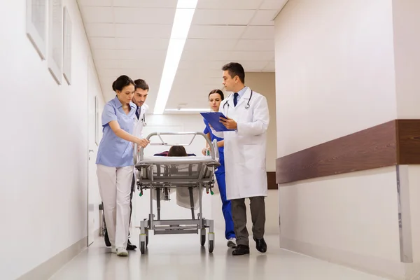 Médicos con la mujer en la camilla del hospital en caso de emergencia — Foto de Stock