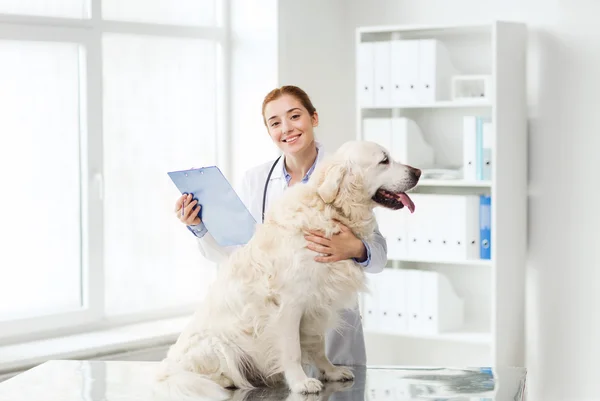 Щасливий лікар з собакою-ретривером у ветеринарній клініці — стокове фото
