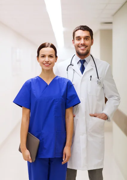 smiling doctor in white coat and nurse at hospital