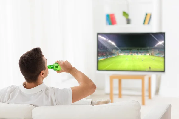 男人看着电视上的足球比赛 — 图库照片