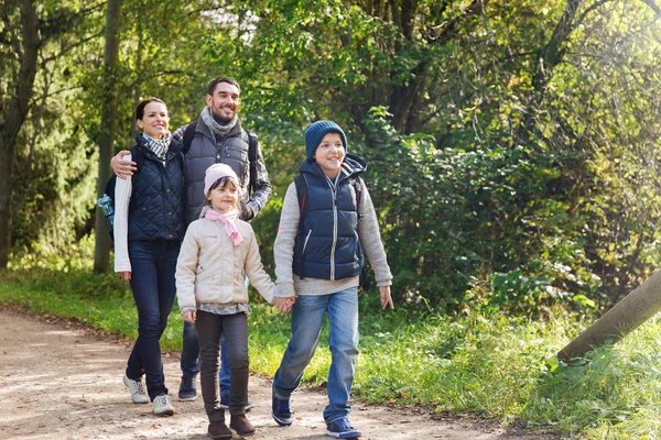 Famille heureuse avec sacs à dos randonnée dans les bois — Photo