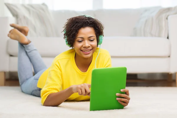 Femme africaine heureuse avec tablette PC et écouteurs — Photo