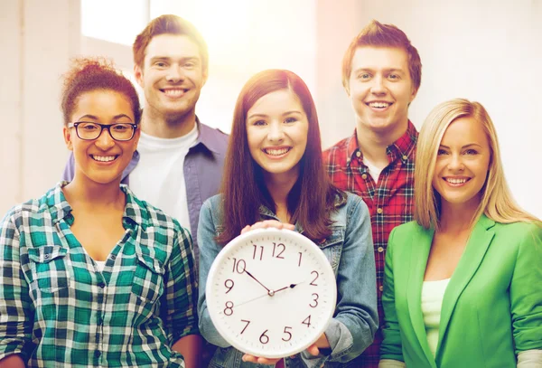 Gruppo di studenti a scuola con orologio — Foto Stock