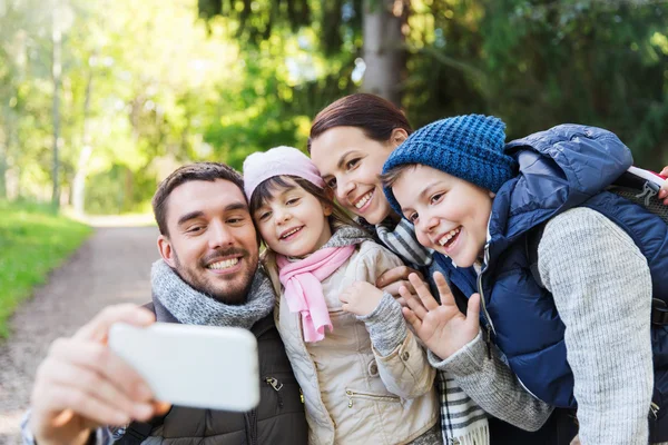 Family with backpacks taking selfie by smartphone — Stock Photo, Image