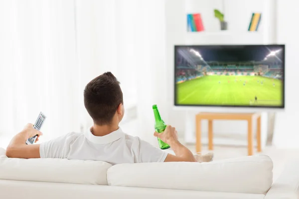 Hombre viendo el partido de fútbol en la televisión y beber cerveza —  Fotos de Stock